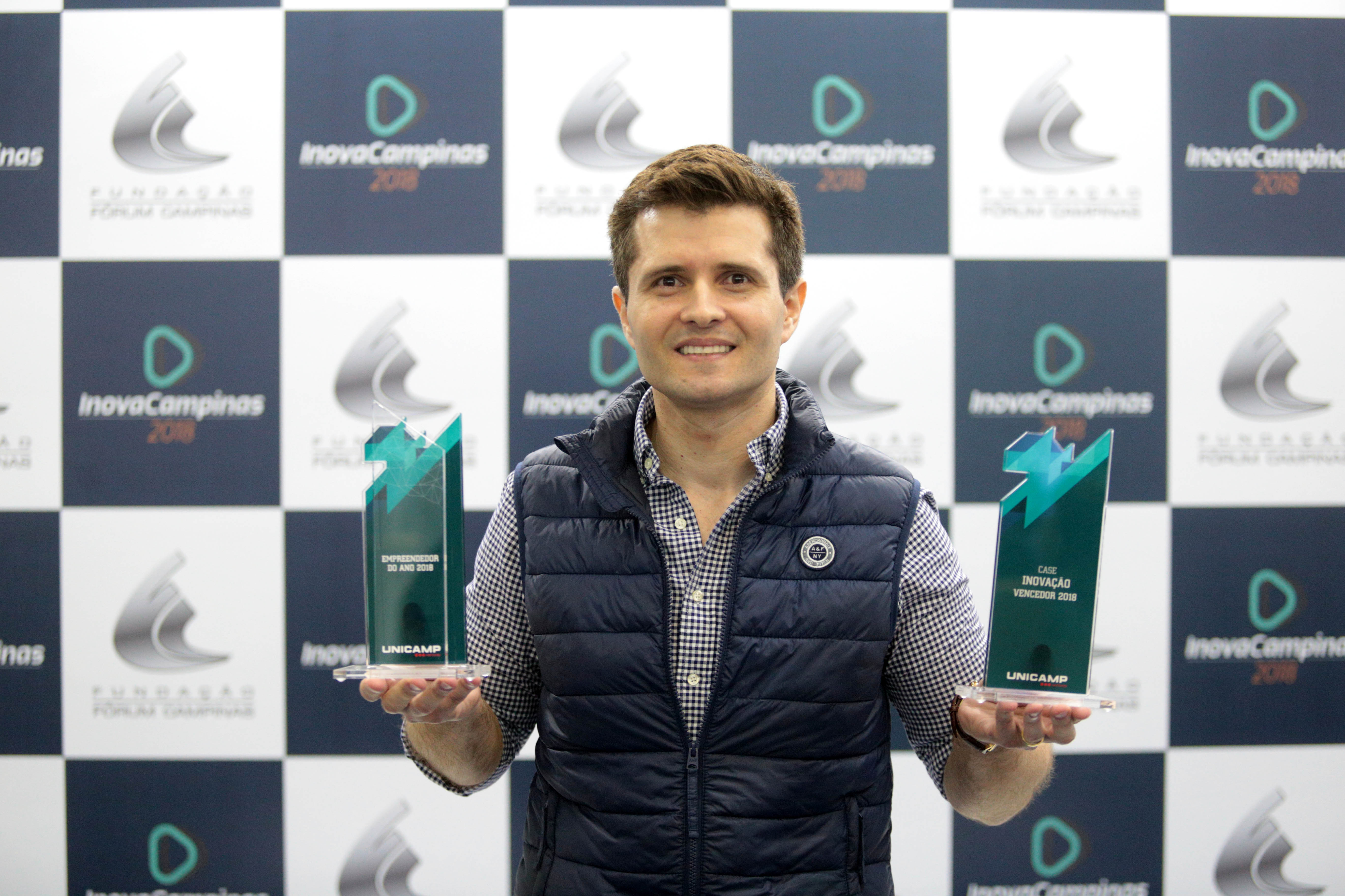 Paulo Gurgel Pinheiro segurando os dois troféus que ganhou no Prêmio Empreendedor